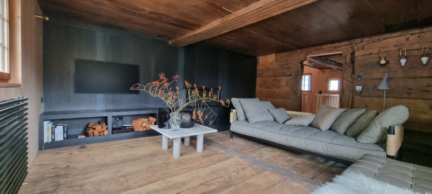Stube nach Umbau mit Speicher-Cheminée in Schwarzstahl