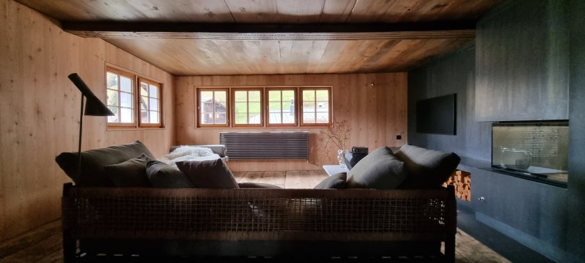 Stube nach Umbau und Einbau Speicher-Cheminée in Schwarzstahl