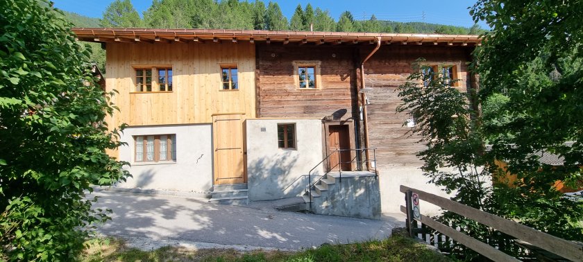Nordfassade mit neuer sägeroher Lärchenholzverschalung des historischen Stallanbaus.